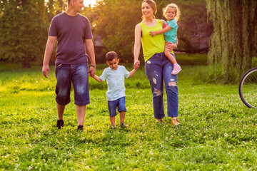 Fototapeta premium Happy family- Young family together enjoying in park.