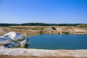 Sand pit filled with water. A developed, flooded quarry. On the shore are white and yellow sand