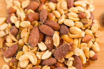 Background of nuts - pecan, macadamia, brazil nut, walnut, almonds, hazelnuts, pistachios, cashews, peanuts, pine nuts - with copy space. Isolated one edge. Top view or flat lay