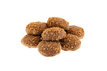 Close up of a pile of delicious crunchy caramel biscuits coated with milk chocolate and biscuit particles, isolated on a white background