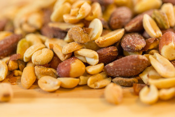 Background of nuts - pecan, macadamia, brazil nut, walnut, almonds, hazelnuts, pistachios, cashews, peanuts, pine nuts - with copy space. Isolated one edge. Top view or flat lay