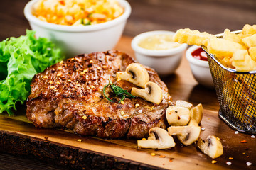 Grilled steak, French fries and vegetable salad 