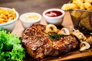 Grilled steak, French fries and vegetable salad 