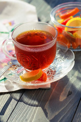 Close up of a morning black tea and colorful marmalades in glass jar on wooden table