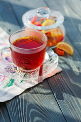 Close up of a morning black tea and colorful marmalades in glass jar on wooden table