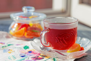 Close up of a morning black tea and colorful marmalades in glass jar on wooden table