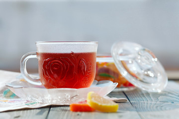 Close up of a morning black tea and colorful marmalades in glass jar on wooden table