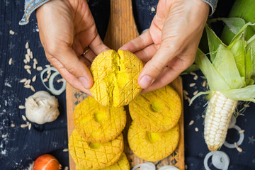 Woman hands cracks Mchadi - traditional Georgian cornbread traditionally eaten with Lobio and suluguni  cheese. Mchadi corn bread of Georgia cuisine. Vegan vegetarian healthy food
