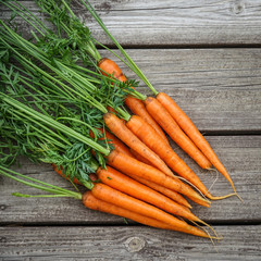 Close-up of bundle of carrots on a rustic wooden table. Concept for vegetarian, organic raw food.
