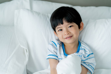 cute and attractive asian boy relax and feel sleepy on his white soft bed morning time