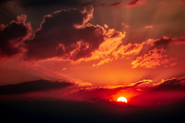 Brilliant sunset with rays of light shining behind the clouds