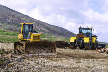 heavy machinery two bulldozers on the construction of roads in the mountains