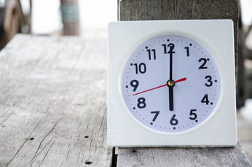 White clock on wooden floor river in the morning.On the river at 6:00 pm, there is a white clock on...