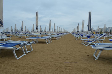 Puste leżaki na plaży w bibione w deszczowy dzień