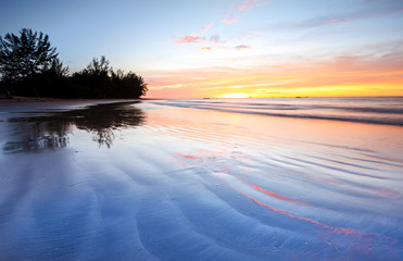 Beautiful and romantic sunset colour at the beach with reflection. suitable for background. 