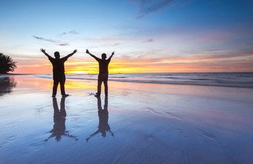 Fototapeta premium two men at the beach during beautiful sunset. 