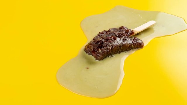 studio shoot of red bean popsicle melting and reverse time lapse on yellow background