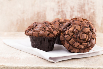 Homemade muffins with chocolate, vintage background.
