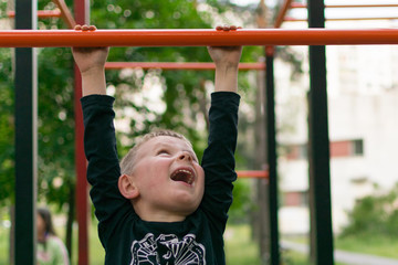 Obraz premium A little boy on the bar. Physical activity and development of the child.