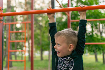 Fototapeta premium A little boy on the bar. Physical activity and development of the child.