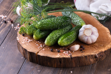 Pile of cucumbers ready for pickling with garlic and dill on table