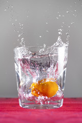 Orange mandarin splashing into fresh water