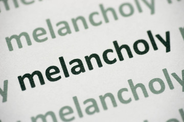 Fototapeta premium word melancholy printed on paper macro