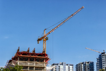 Towers of the cranes. Construction site with cranes against the blue sky.