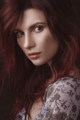 Fototapeta premium Dramatic retro portrait of a young beautiful dreamy redhead woman. Soft vintage toning.