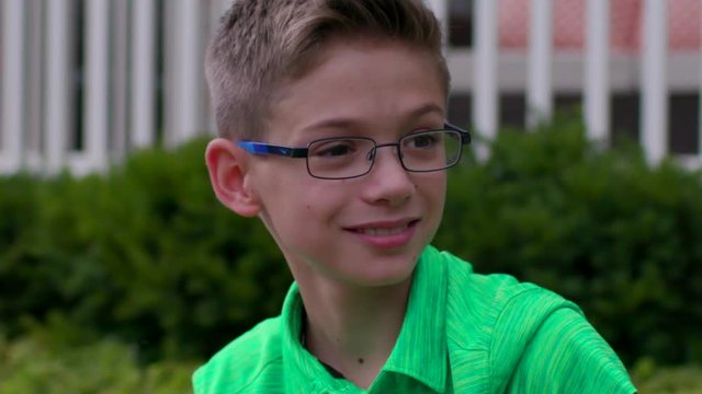 Cute little middle school aged boy looks down the street waiting for guests