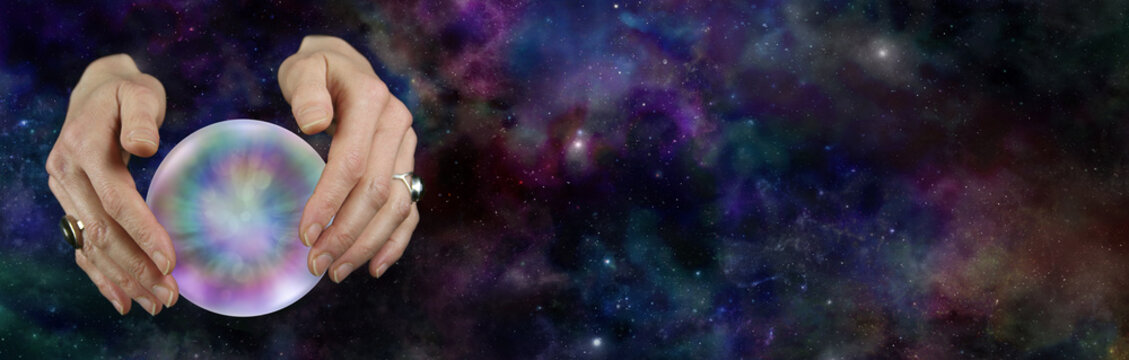 Take a look at the future with a Crystal Ball Reading - female hands hovering over a large scrying ball against a deep space background with plenty of copy space on the right
