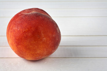 Delicious peaches on a white wooden background.