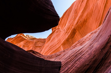 Orange peach wave shapes photographed at slots canyons in Arizona with blue sky