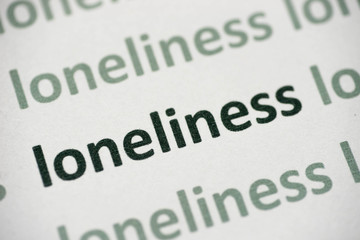 word loneliness printed on paper macro