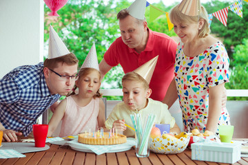 Colorful portrait of happy family celebrate birthday and grandparents blows candles with children