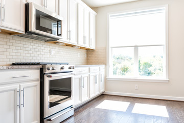 Modern gray, brown neutral kitchen features front cabinets with granite countertops and tile...