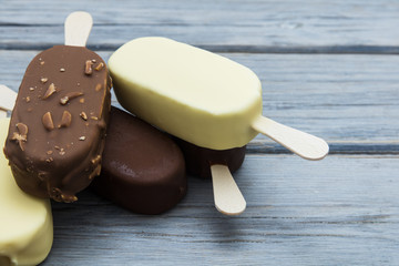 Chocolate ice cream lollies on a wooden background.