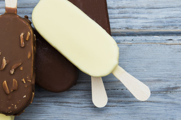 Chocolate ice cream lollies on a wooden background.