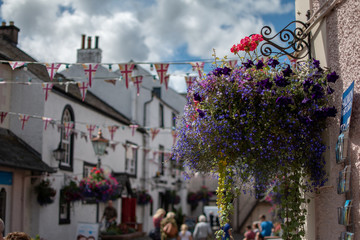 A hanging basket of colourful flowers in a rural town