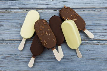 Chocolate ice cream lollies on a wooden background.