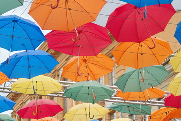 Colorful umbrellas float along the alley.