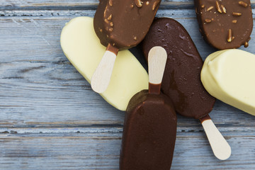 Chocolate ice cream lollies on a wooden background.