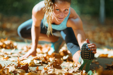 Woman stretching in the park, in the fall.