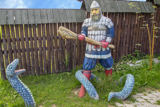 The Russian fantastic hero with a cudgel in hands battles against a dragon