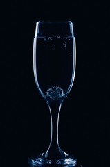 A glass for champagne with a glass ball and bubbles in blue style