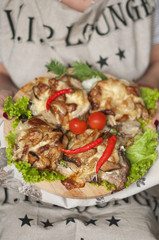 baked chicken on a large platter. in the hands of food. useful dinner. healthy eating