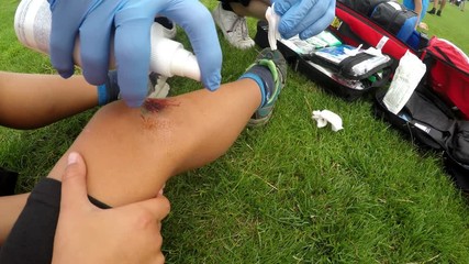 Treatment of knee injury.
A medical practitioner provides first aid for injury to a part of the body.