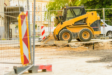 Orange dredger at a building site in the city. Construction of sewerage in the area. Parked work...