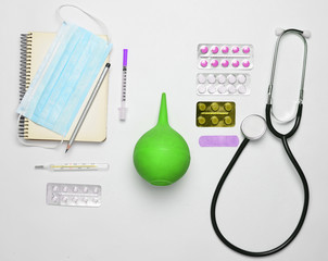 Medical equipment on a white background. Stethoscope, tablet, thermometer, notebook, syringe,...