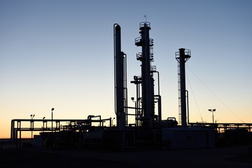 Dawn silhouette of pipes and towers at a natural gas processing facility near Casper, Wyoming